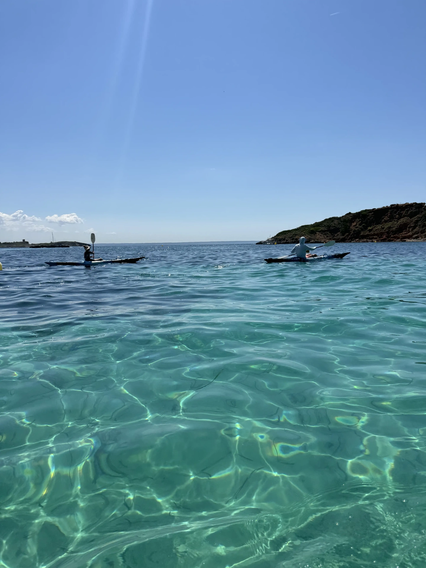 Kayaking through clear water in a Mallorcan cala