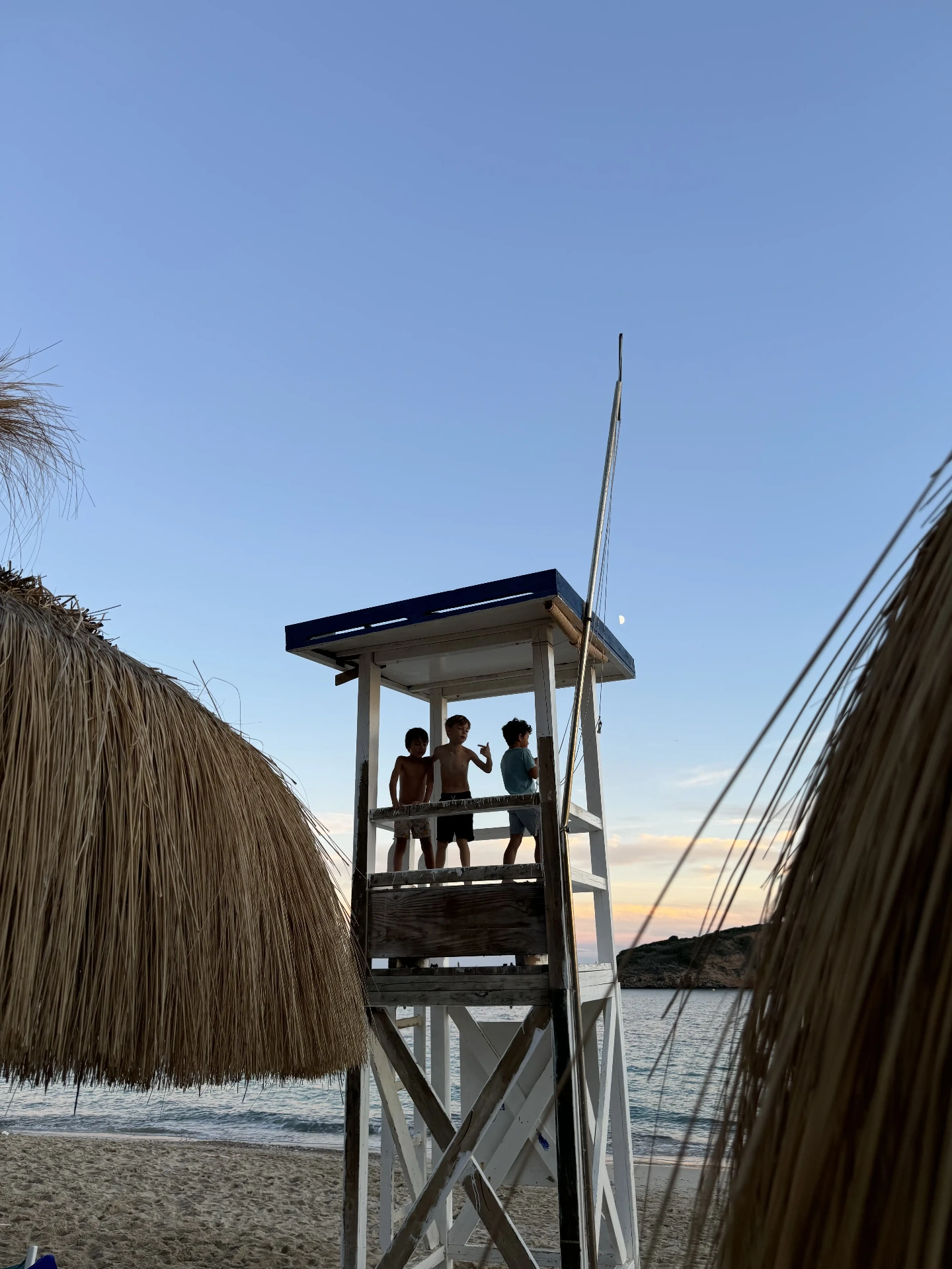 Kids on a lifeguard tower at sunset on a Mallorca beach